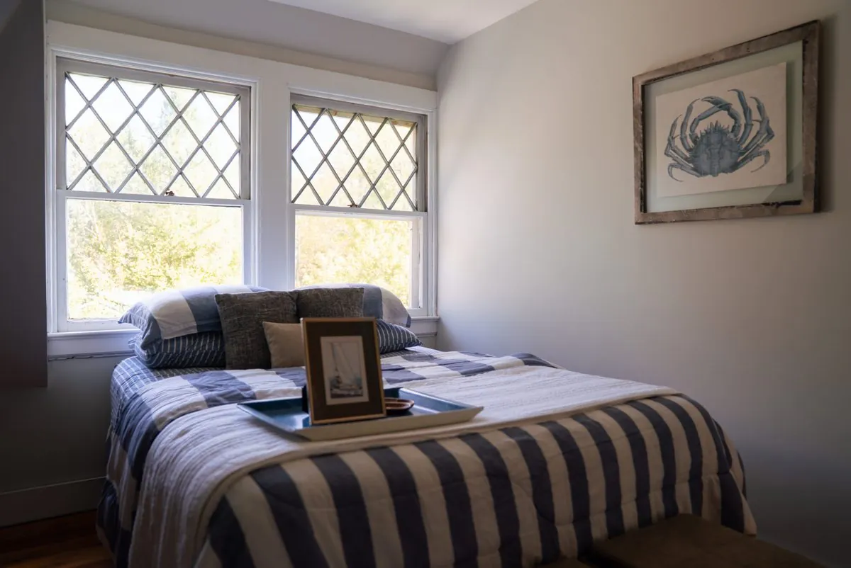 Bedroom with a navy and white striped bed under sloped ceilings