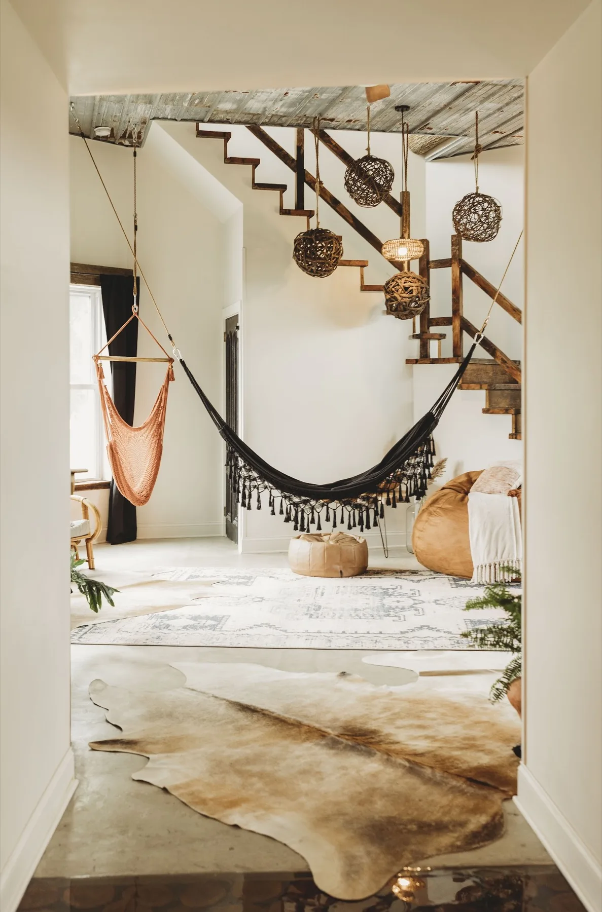 Two hanging rattan swing chairs in the Southview great room beside the open stair