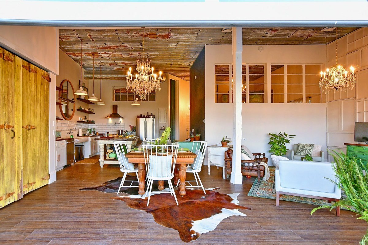 Inside Highbanks at the West Barn: crystal chandeliers, a cowhide rug and the long dining table